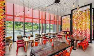 Kahvila, jossa on värikkäitä huonekaluja ja koristeelliset seinät. (Tekoälyn luoma teksti)