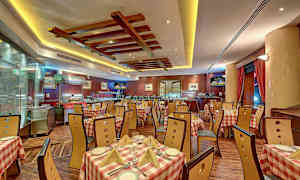 Ruokailutila, jossa on ruudulliset pöytäliinat ja puukalusteet, sijaitsee tyylikkäässä ravintolassa harmonisen valaistuksen kanssa. (Tekoälyn luoma teksti)