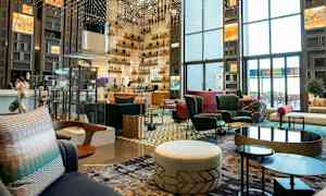 Modernin hotellin tai loungen sisätila, jossa on istuimia ja koriste-elementtejä. (Tekoälyn luoma teksti)