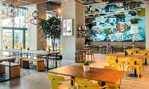 Ravintola, jossa on nykyaikaiset kalusteet ja värikäs seinämaalaus. (Tekoälyn luoma teksti)