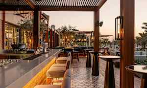 Ulkobaari, jossa istumapaikkoja ja pöytiä iltavalossa. (Tekoälyn luoma teksti)