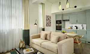 Modernisti sisustettu olohuone, jossa beige sohva, ruokapöytä ja avoin keittiötila. (Tekoälyn luoma teksti)