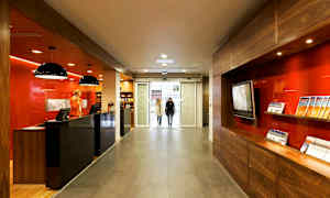 Vastaanotto, jossa on moderni sisustus ja esitteitä, sijaitsee lasioven lähellä. (Tekoälyn luoma teksti)