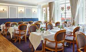 Sisäkuva ruokailutilasta, jossa on järjestetty pöytiä ja tuoleja. (Tekoälyn luoma teksti)