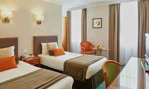 Hotellihuone, jossa kaksi yhden hengen vuodetta ja pöytä. (Tekoälyn luoma teksti)