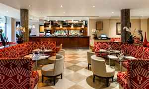 Ravintola, jossa punaiset sohvat ja lasipöydät. (Tekoälyn luoma teksti)