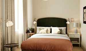 Hotellihuone, jossa on parivuode, kaksi yöpöytää ja koristeellisia yksityiskohtia. (Tekoälyn luoma teksti)