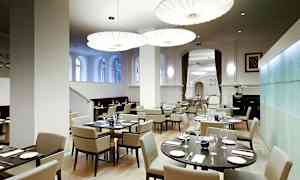 Moderni ravintola, jossa on tyylikäs sisustus ja elegantti valaistus. (Tekoälyn luoma teksti)