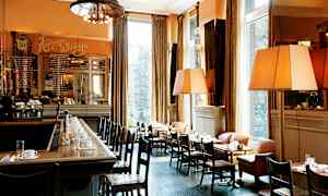 Tyylikäs bistro, jossa on baari ja pöytiä, jotka on järjestetty suurten ikkunoiden äärelle. (Tekoälyn luoma teksti)