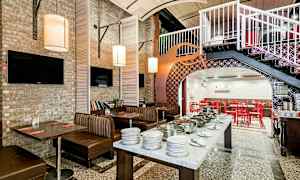 Ravintolatila, jossa on istumapaikkoja, pöytiä ja buffetpöytä. (Tekoälyn luoma teksti)