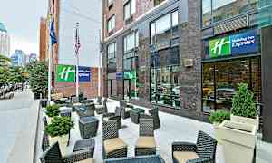 Hotellin edessä oleva ulkoterassi, jossa on istuinryhmiä ja kasvikoristeita. (Tekoälyn luoma teksti)