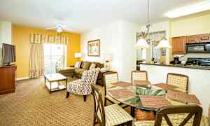 Kuva tilavasta olohuoneesta ja ruokailutilasta, jossa on sohva, nojatuoli, ruokapöytä ja keittonurkkaus. (Tekoälyn luoma teksti)