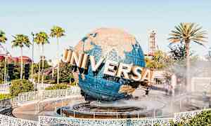 Suuri maapallo, jossa lukee "Universal", seisoo suihkulähteen keskellä, palmut ja huvipuisto ympäröivät sitä. (Tekoälyn luoma teksti)