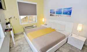 Hotellihuone, jossa on parivuode, valkoinen sisustus ja koristelu. (Tekoälyn luoma teksti)