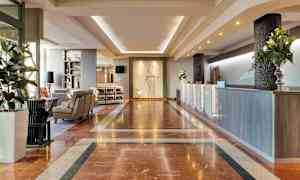 Hotellin aula marmorisella lattialla, vastaanotto ja istuinryhmä. (Tekoälyn luoma teksti)