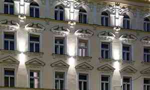 Ulkoseinä valaistuksella ja koristelluilla ikkunoilla. (Tekoälyn luoma teksti)