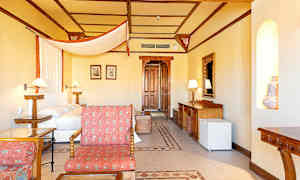 Hotellihuone, jossa on sänky, puuyksityiskohtia ja oleskelualue. (Tekoälyn luoma teksti)