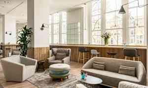 Moderni lounge-tila, jossa sohvia ja nojatuoleja, suuret ikkunat. (Tekoälyn luoma teksti)