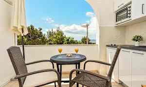 Parveke pöytä, tuolit ja näkymä. (Tekoälyn luoma teksti)