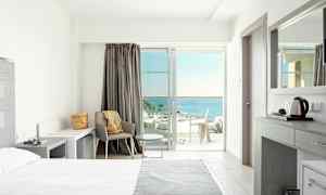 Vaalea hotellihuone nykyaikaisella sisustuksella ja merinäköalalla. (Tekoälyn luoma teksti)