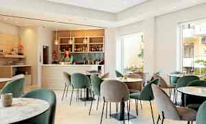 Nykyaikainen lounge, jossa pöydät ja tuolit sekä hyvin varusteltu baari. (Tekoälyn luoma teksti)