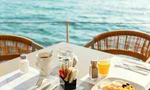 Aamiainen tarjoillaan pöydässä, josta on näkymä vesistöön. (Tekoälyn luoma teksti)