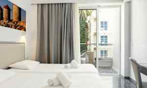 Hotellihuone, jossa on kaksi yhden hengen vuodetta, parveke näkymällä. (Tekoälyn luoma teksti)