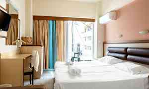 Hotellihuone, jossa on parivuode ja kirjoituspöytä sekä parveke ja näkymä. (Tekoälyn luoma teksti)