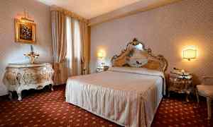 Tyylikkäästi sisustettu makuuhuone, jossa suuri vuode, yhteensopivat yöpöydät ja koristeelliset huonekalut. (Tekoälyn luoma teksti)