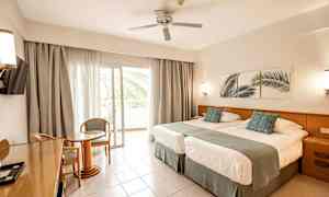 Hotellihuone, jossa kaksi vuodetta, oleskelutila ja parveke. (Tekoälyn luoma teksti)