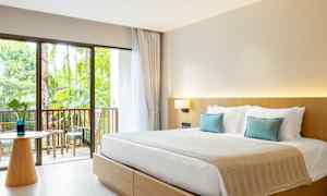 Hotellihuone, jossa on parisänky, vaaleat huonekalut ja parveke puutarhaan päin. (Tekoälyn luoma teksti)