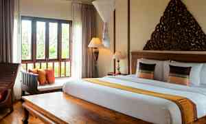 Kuva makuuhuoneesta, jossa on parivuode, ikkuna ja koristeellinen puusisustus. (Tekoälyn luoma teksti)