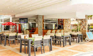 Ravintola, jolla on ulkoterassi ja baari, ympäröitynä tuoleilla ja pöydillä. (Tekoälyn luoma teksti)