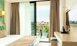 Hotellihuone, jossa parveke ja näkymä uima-allasalueelle. (Tekoälyn luoma teksti)