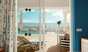 Kuva aurinkotuolista ja uima-altaasta, katsottuna terassilta lasiovien läpi. (Tekoälyn luoma teksti)