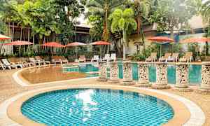 Ulkoilma-allas, jota ympäröivät palmupuut ja aurinkotuolit varjolla. (Tekoälyn luoma teksti)