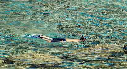 Henkilö snorkkelilla uimassa kirkkaassa vedessä. (Tekoälyn luoma teksti)