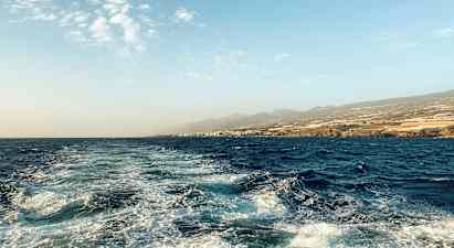 Meri maisema, jossa aaltoja ja rantaviivaa taustalla. (Tekoälyn luoma teksti)