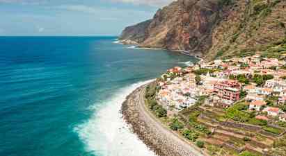 Näkymä rannikkoviivalle, jossa kylä sijaitsee kallion päällä ja taustalla on meri. (Tekoälyn luoma teksti)