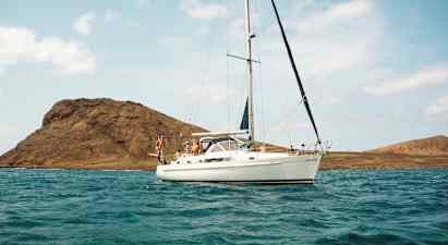 Purjevene vedessä, taustalla vuoria. (Tekoälyn luoma teksti)