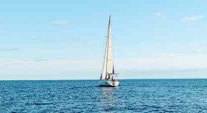 Purjevene purjehtii avoimella merellä kirkkaan taivaan alla. (Tekoälyn luoma teksti)