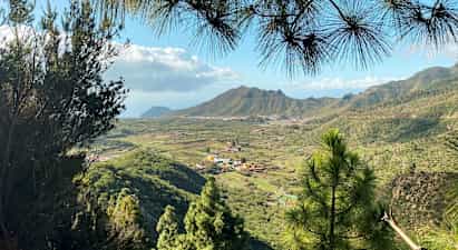 Näkymä vihreään laakson alueeseen, jossa on kyliä ja vuoria taustalla. (Tekoälyn luoma teksti)