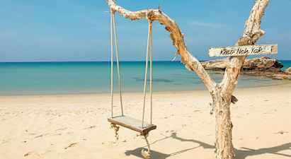 Puinen keinu roikkuu narusta rannalla, taustalla sininen meri. (Tekoälyn luoma teksti)