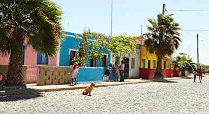 Katu värikkäiden talojen, palmujen ja kävelevien ihmisten kanssa. (Tekoälyn luoma teksti)