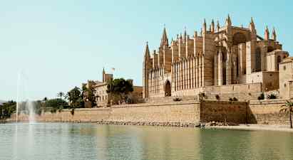 Katedraali veden äärellä suihkulähde etualalla. (Tekoälyn luoma teksti)