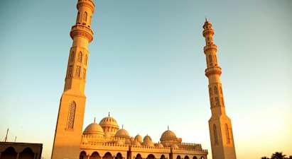 Suuri moskeija, jossa on kaksi korkeaa minareettia ja kupolia. (Tekoälyn luoma teksti)