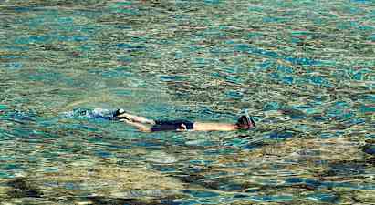 Henkilö snorkkelilla uimassa kirkkaassa vedessä. (Tekoälyn luoma teksti)