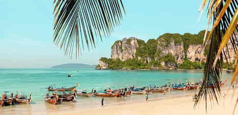 Ranta, jolla on pitkän perän veneitä ja kallioita meren äärellä. (Tekoälyn luoma teksti)