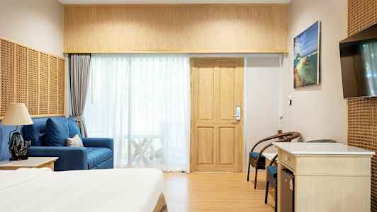 Hotellihuone, jossa sänky, istuimet ja televisio. (Tekoälyn luoma teksti)