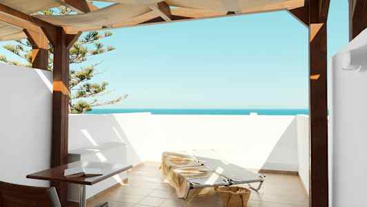 Terasii merinäköalalla, aurinkotuoleja ja pöytä katoksen alla. (Tekoälyn luoma teksti)